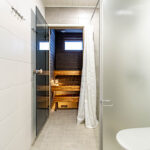 Kylpyhuone: Käytävä jossa vasemmalla WC, suihku ja perällä valaistu sauna.