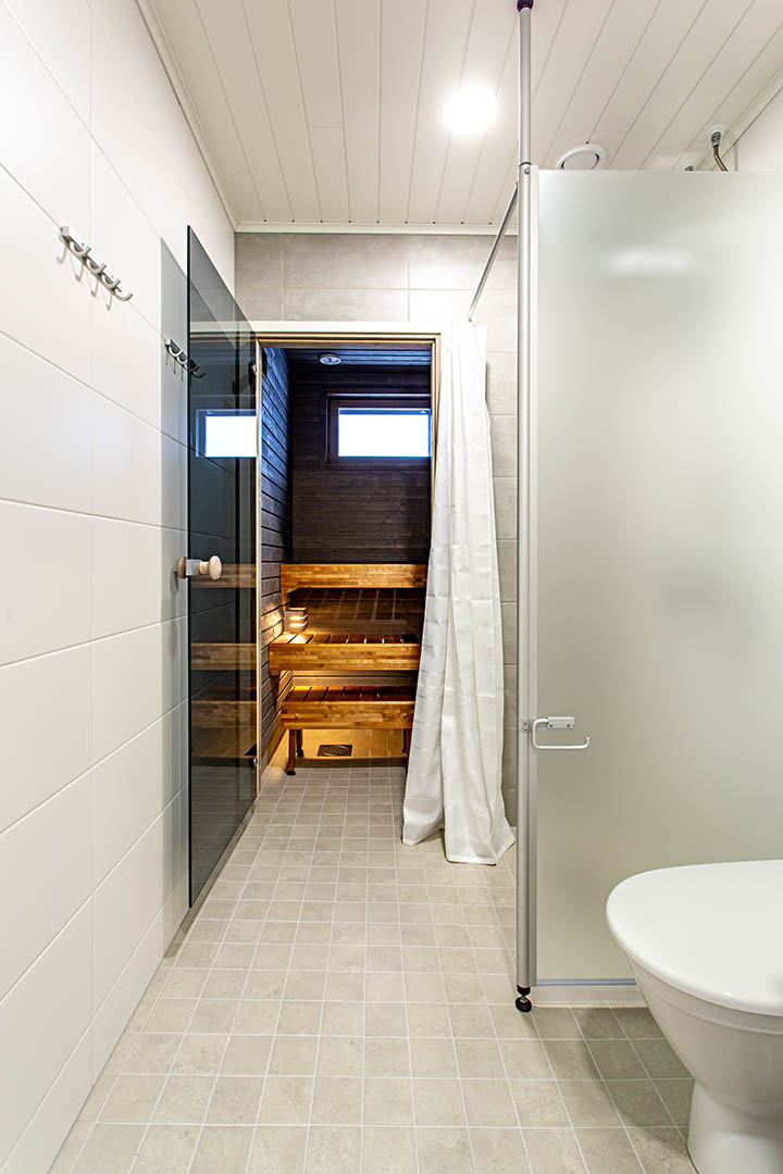 Kylpyhuone: Käytävä jossa vasemmalla WC, suihku ja perällä valaistu sauna.